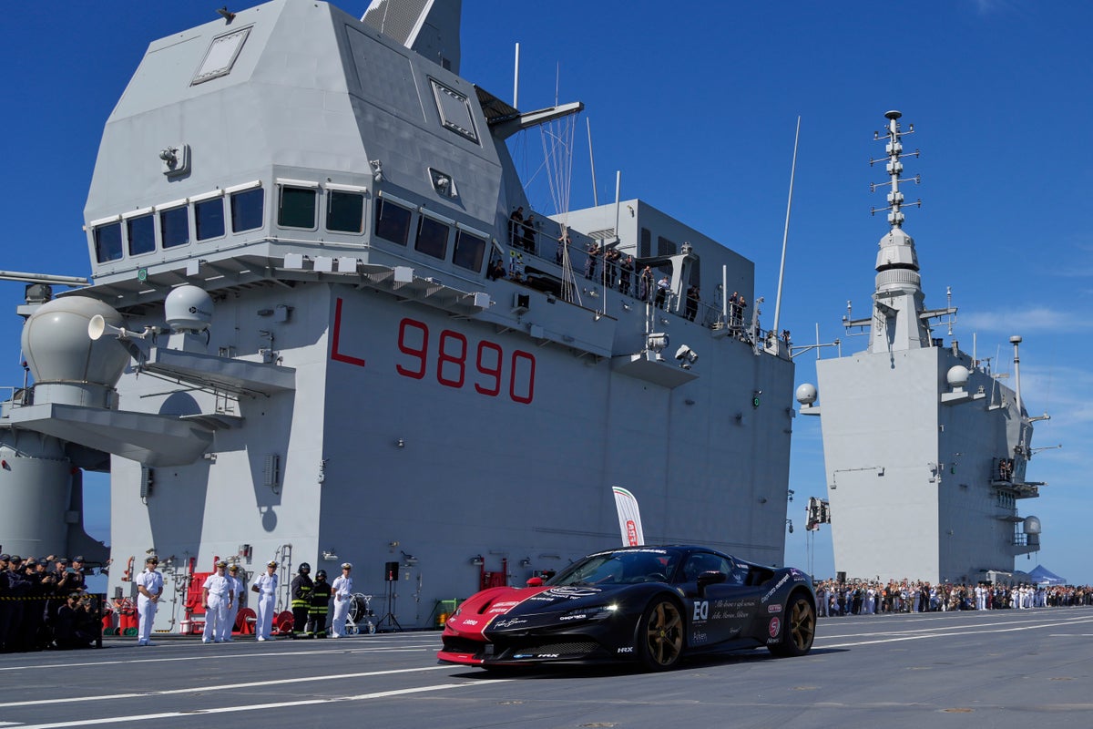 One man in an Italian supercar atop an aircraft carrier. And a record in his sights