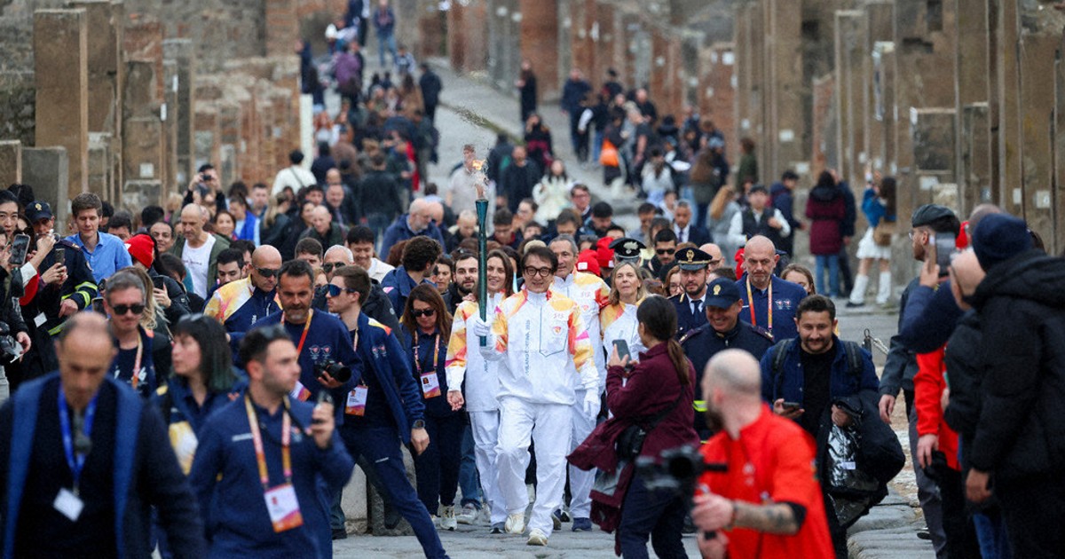 Jackie Chan carries the Milan Cortina Olympic torch through the ruins of Pompeii