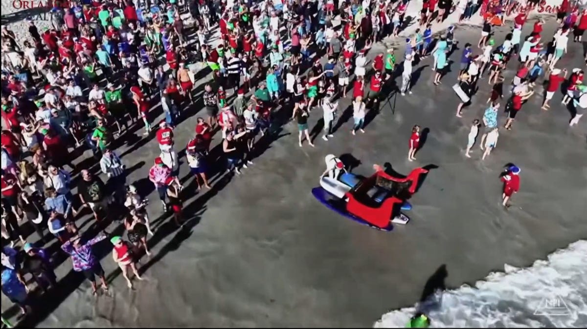 Surfing Santas hit the waves on Christmas Eve. See video.