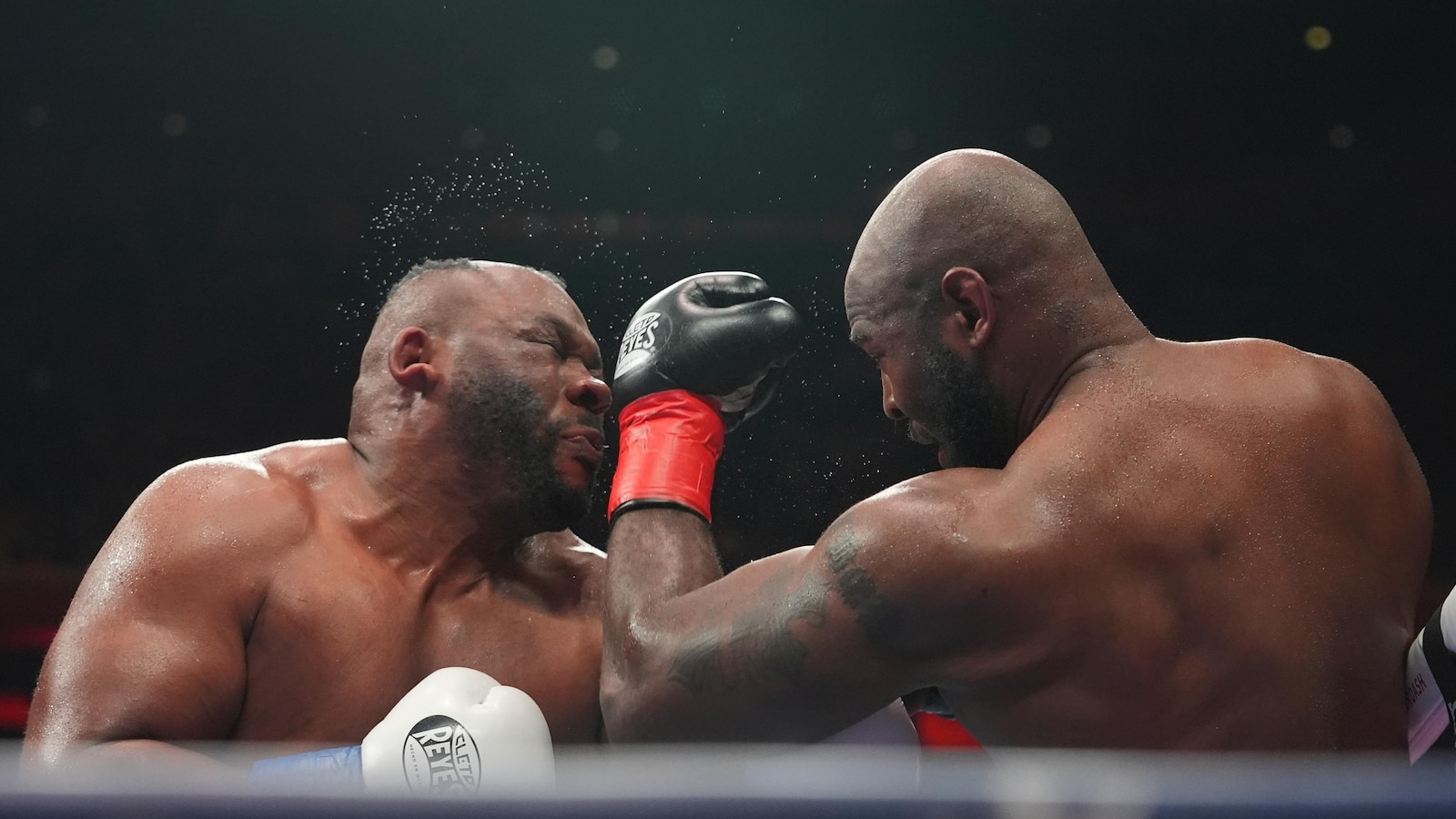 Boxer Jarrell Miller has hairpiece knocked upward by punch, throws it into the crowd