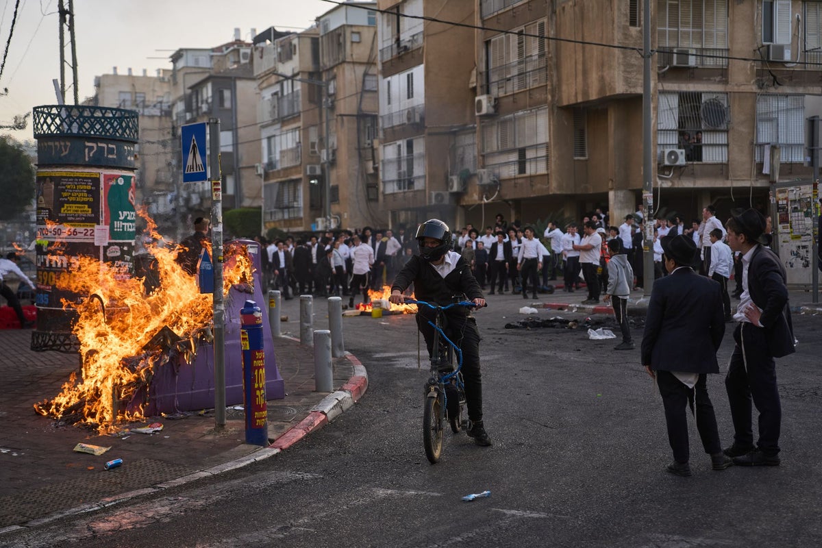 Two female Israeli soldiers chased by huge crowd of ultra-Orthodox men during riot