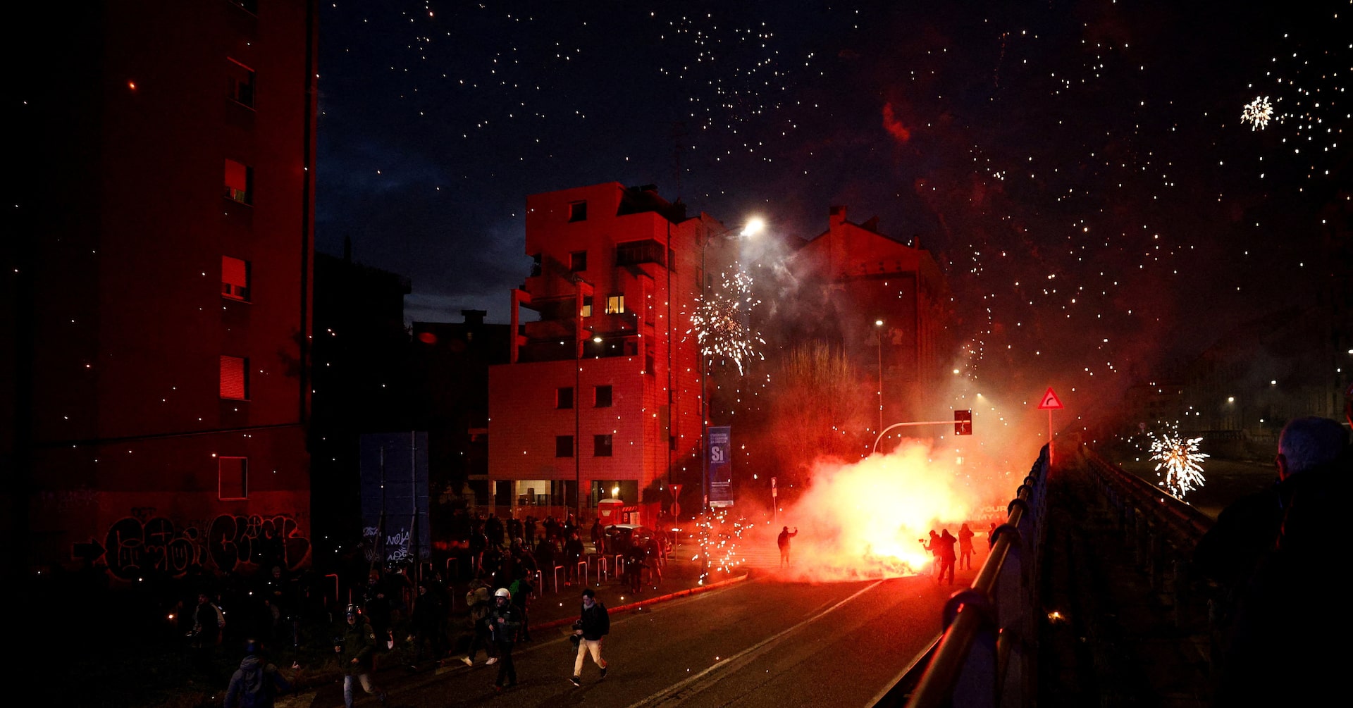 Hooded protesters throw flares at police at end of demonstration in Olympic host city Milan